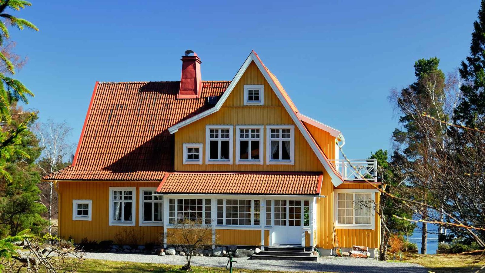 Yellow craftsman house with a brick chimney