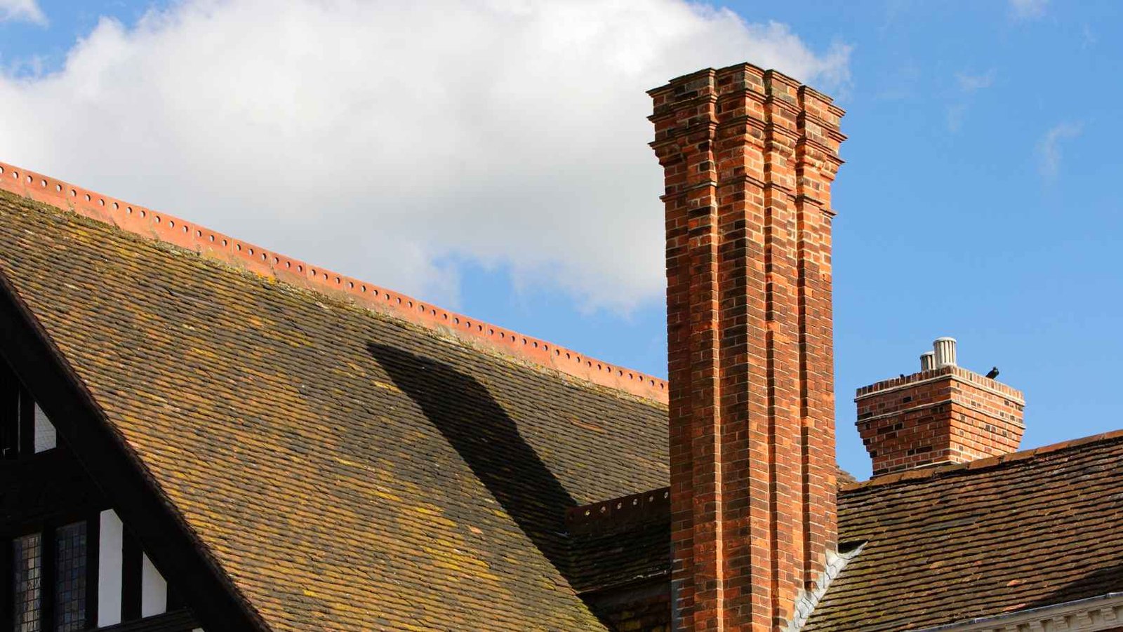 Tall brick chimney on a tile roof