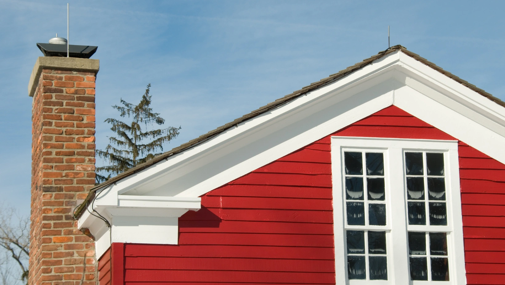Red wooden house with a brick chimney