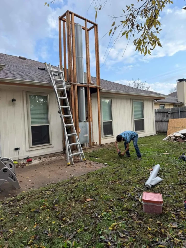 Exterior metal chimney installation with ladder access